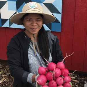 Woman holding a bundle of produce