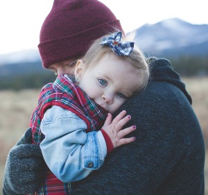 Father hugging his daughter outside in the cold